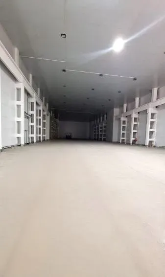 Ақ қабырғалары мен жарықтандыруы бар үлкен бөлменің ішкі көрінісі