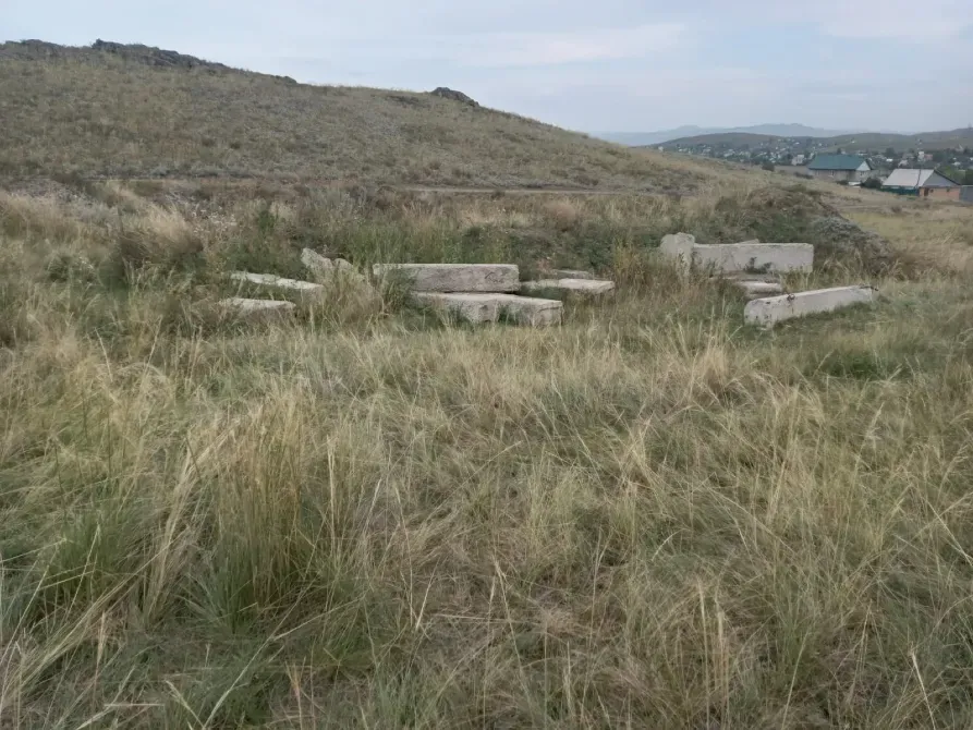 Каменные блоки на травяной местности с холмами на заднем плане