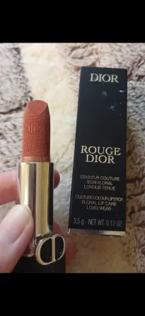 Упаковка помады Dior Rouge на фоне чека