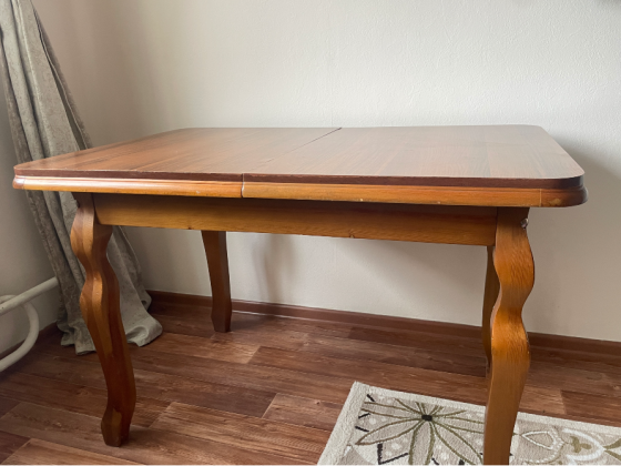 Жарқын интерьердегі қисық аяқтары бар ағаш үстел