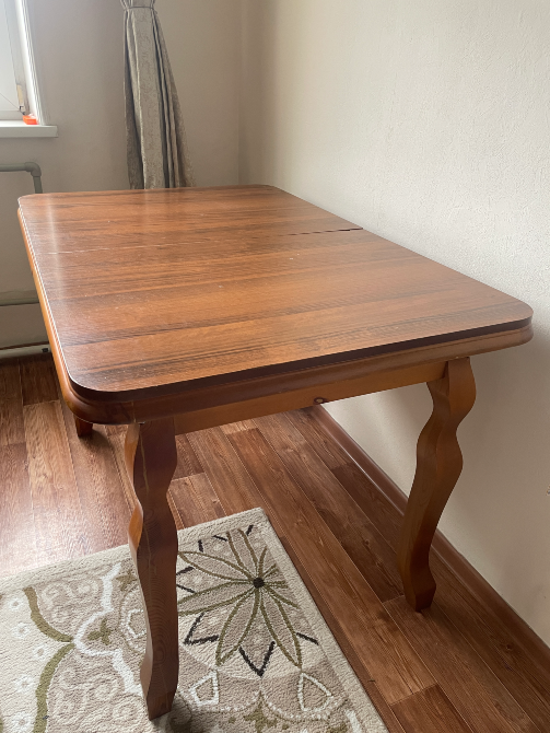 Жарқын интерьердегі қисық аяқтары бар ағаш үстел