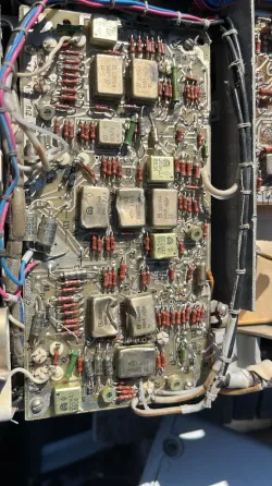 Кучи электронных плат, собранных на земле среди камней