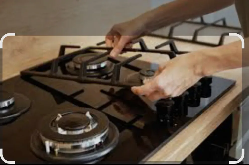 Человек устанавливает решетку на газовой плите