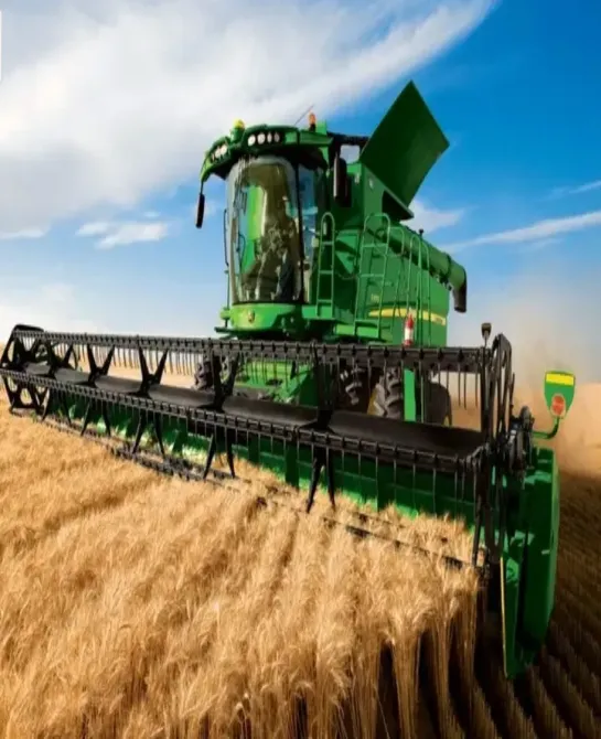 Сары жапырақпен жабдықталған комбайн көк аспан фонында бидай өнімін жинап жатыр.