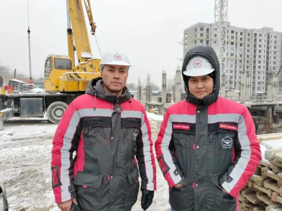 Рабочие на строительной площадке в зимней одежде с касками