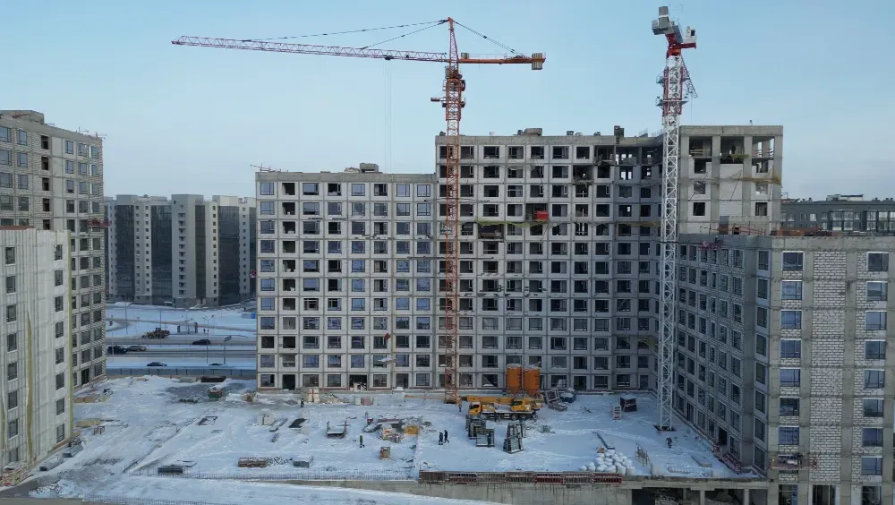 Внешний вид строительного объекта с кранами и рабочими