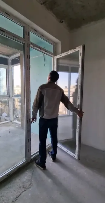 Рабочий закрывает двери на строительном объекте