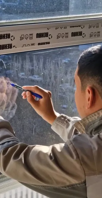 Рабочий выполняет функцию чистки стекла окон