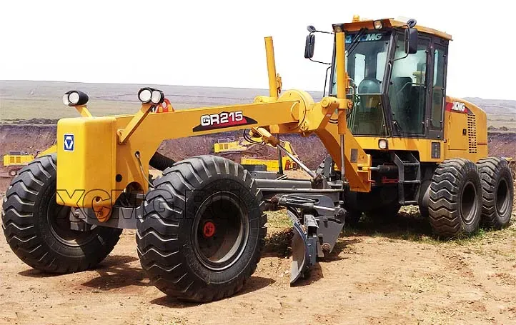 Грейдер с жёлтой окраской и шнеком на фоне гористой местности