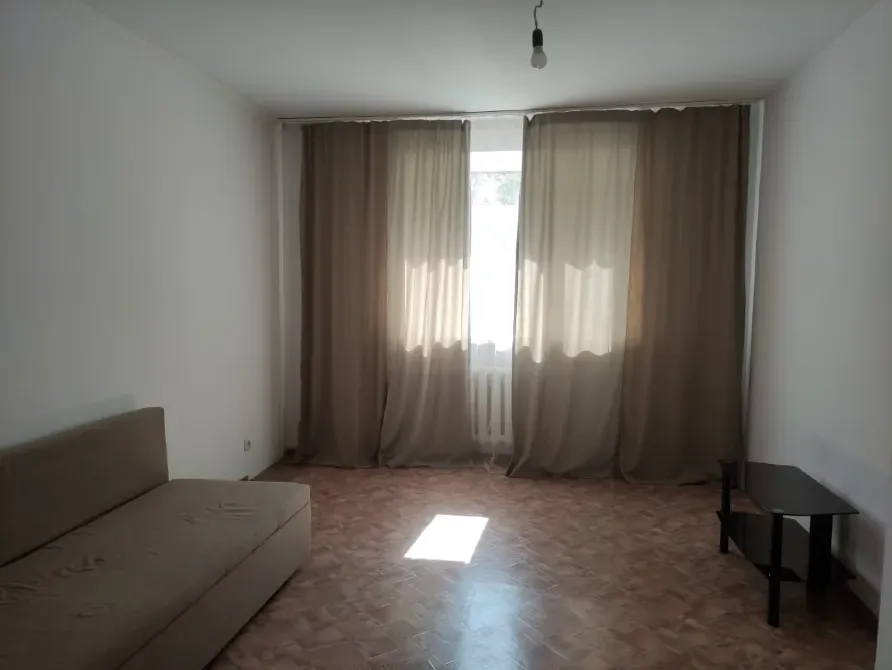 Пустая комната с диваном и занавесками