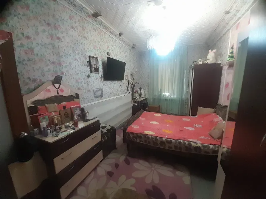 Спальня с телевизором и цветочным декором на стенах