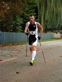 Мужчина, бегущий с палками для скандинавской ходьбы на спортивном мероприятии