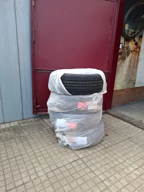 Шины, упакованные в защитные пленки, сложенные в компактную стопку у дверей магазина