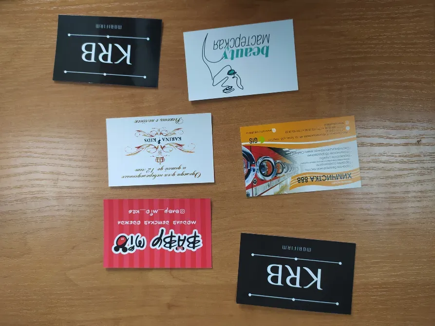 Әр түрлі компаниялардың визиткалары ағаш үстелде