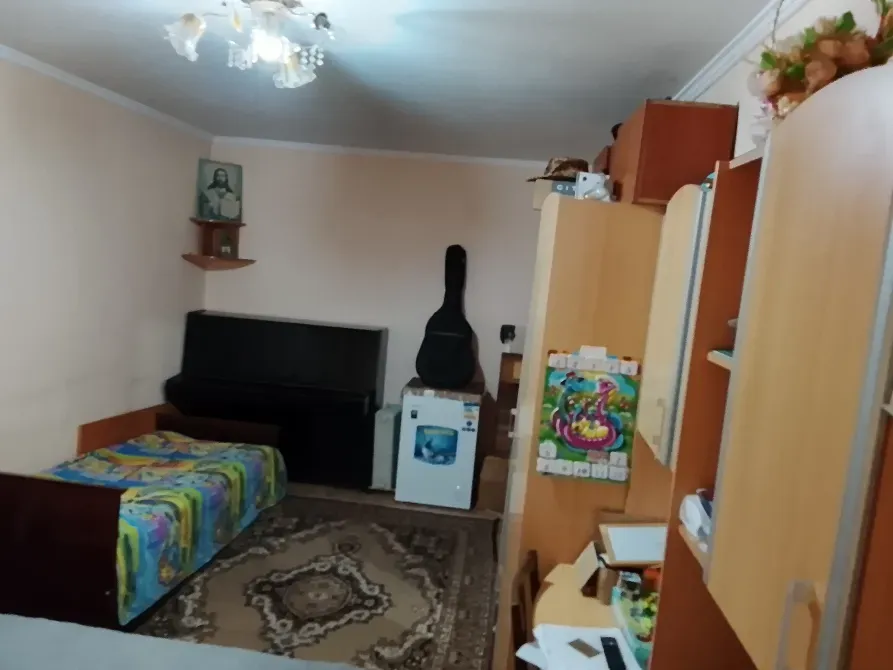 Диван, гитара және жұмсақ жарықы бар қабырға сынды қонақ бөлме