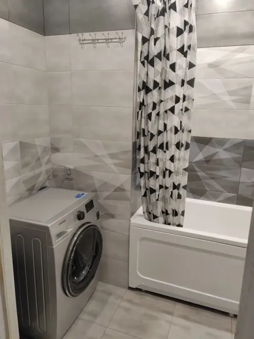 Стиральная машина и ванна в ванной комнате с современным дизайном