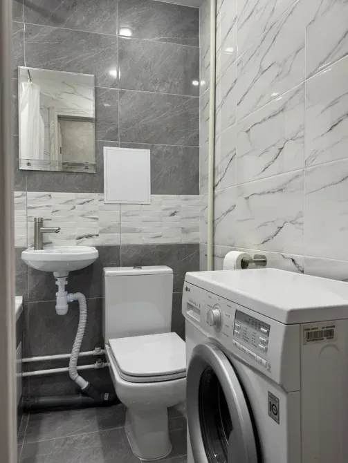 Ыңғайлы ванна бөлмесі дәретханамен және кір жуатын машинамен