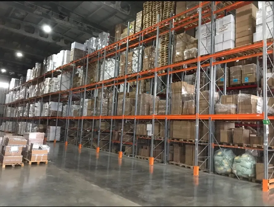 широкие стеллажи в складе с коробками и палетами