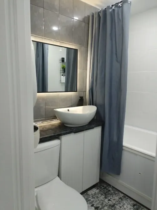 Ванная комната с белой раковиной и аккуратной отделкой