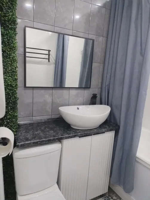 Современная ванная комната с раковиной на столешнице и зеркалом