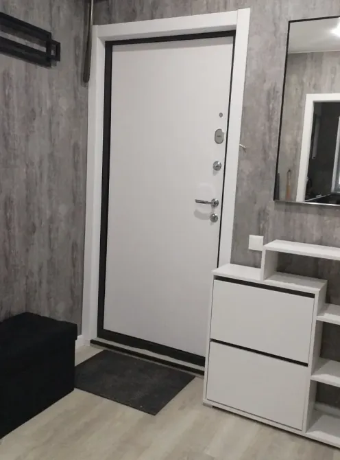 Прихожая с белой дверью и шкафчиком для хранения