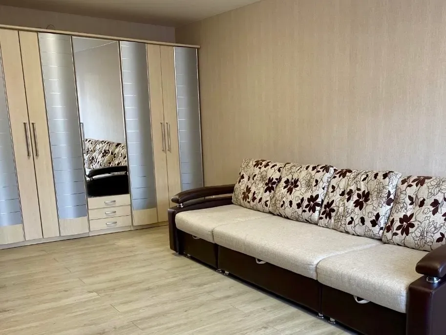 Уютты қонақ бөлмесі диванмен және айна шкафпен