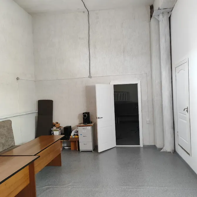 Общее пространство с черными стульями и дверью