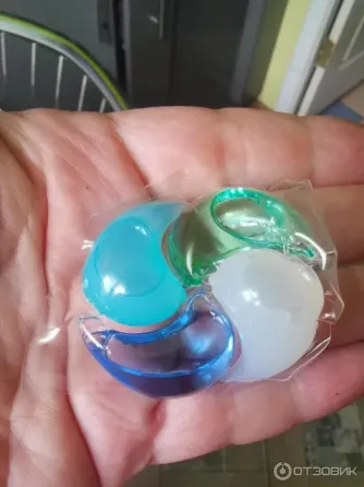 пакет с капсулами для стирки в руке