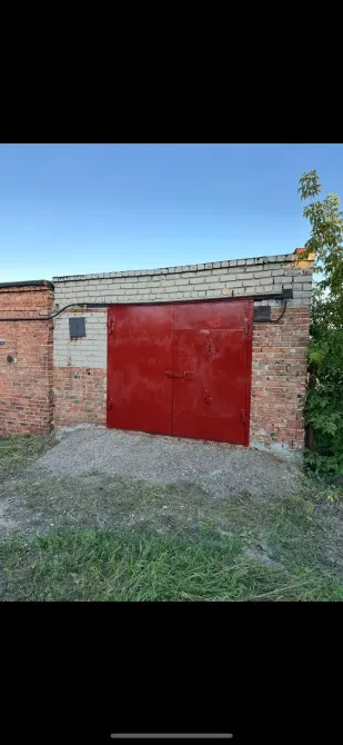 Красные металлические двери на кирпичной стене гаража