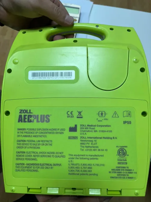 Задняя часть дефибриллятора ZOLL AED Plus с указанием модели и информации о производителе