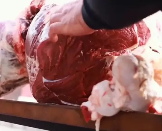 мясо на столе с руками, работающими над ним