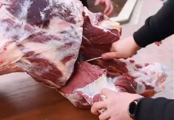 мясо на столе с руками, работающими над ним