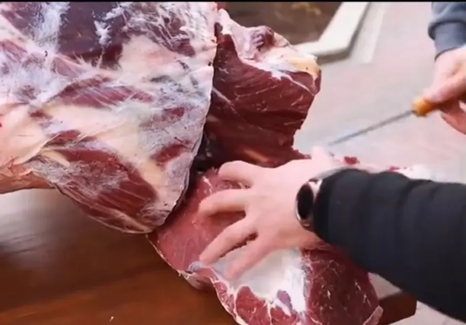 детальды кадр, айналасында адам етті пышақпен бөлшектеп жатыр