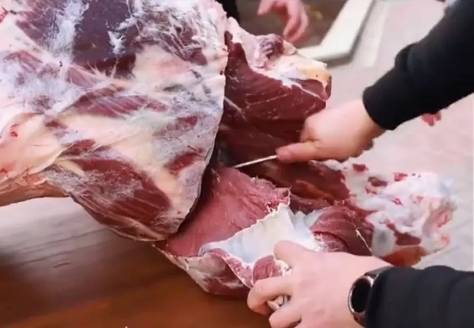 адам таблицада ет кесу үшін пышақ пайдаланып отыр