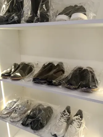 Обувь с белыми кожаными кроссовками, показанными разделённо на две стороны, где одна сторона грязная, а другая чистая