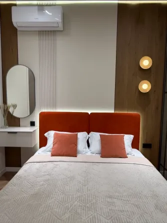 Комната с двуспальной кроватью и телевизором на стене