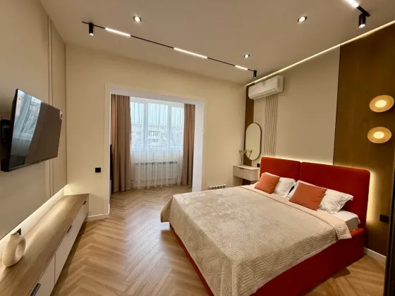 Комната с двуспальной кроватью и телевизором на стене