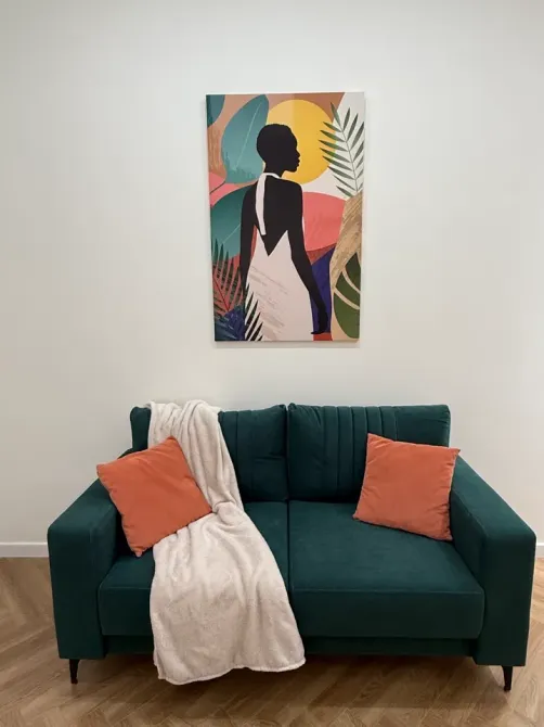 Декоративті жастықтар мен қабырғадағы суреті бар жасыл диван