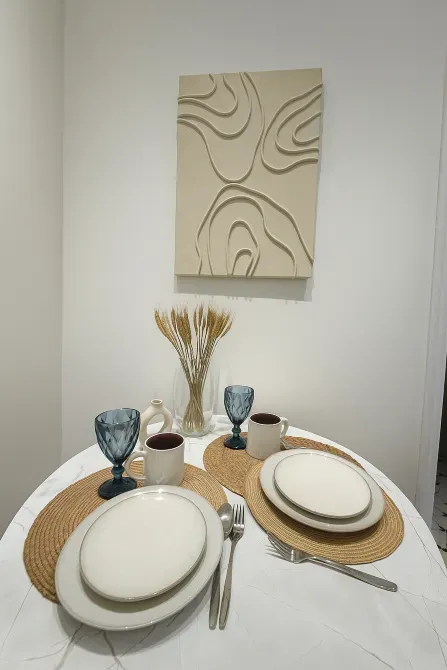 Асхана үстелі сервировкамен және қабырғадағы көркем туындымен