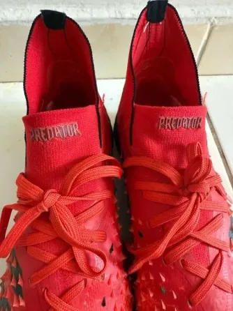 Красные футбольные бутсы с текстурированной поверхностью и шнурками