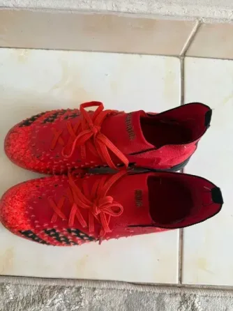 Красные футбольные бутсы с текстурированной поверхностью и шнурками