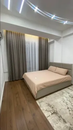 Современный интерьер с телевизором на стене и полками для книг