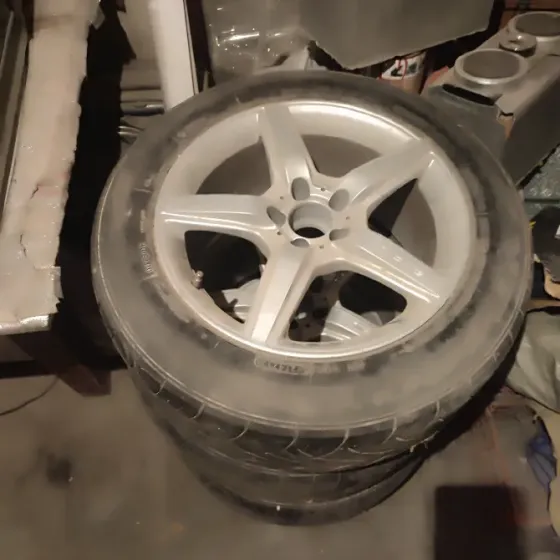 Шины на дисках с несколькими углами обзора, изображенные на фоне гаража