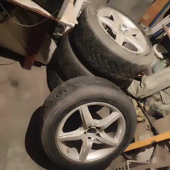 Шины на дисках с несколькими углами обзора, изображенные на фоне гаража