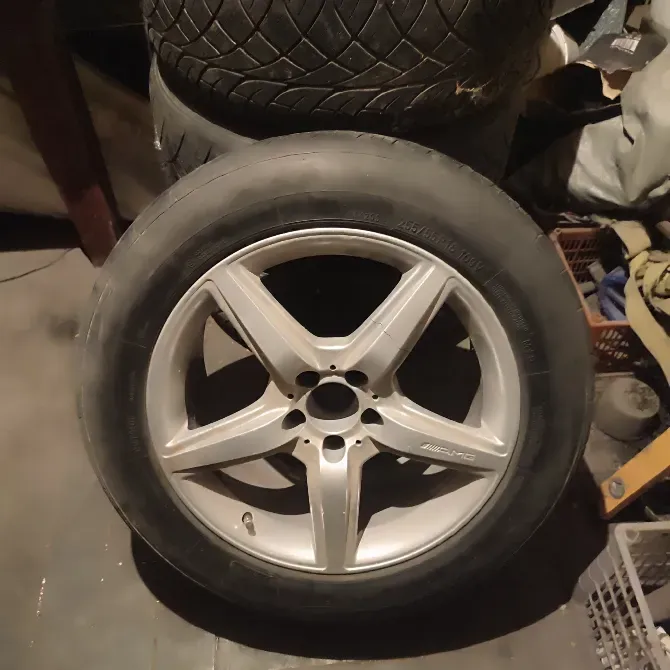 Комплект летних шин с дисками, расположенные на полу в помещении