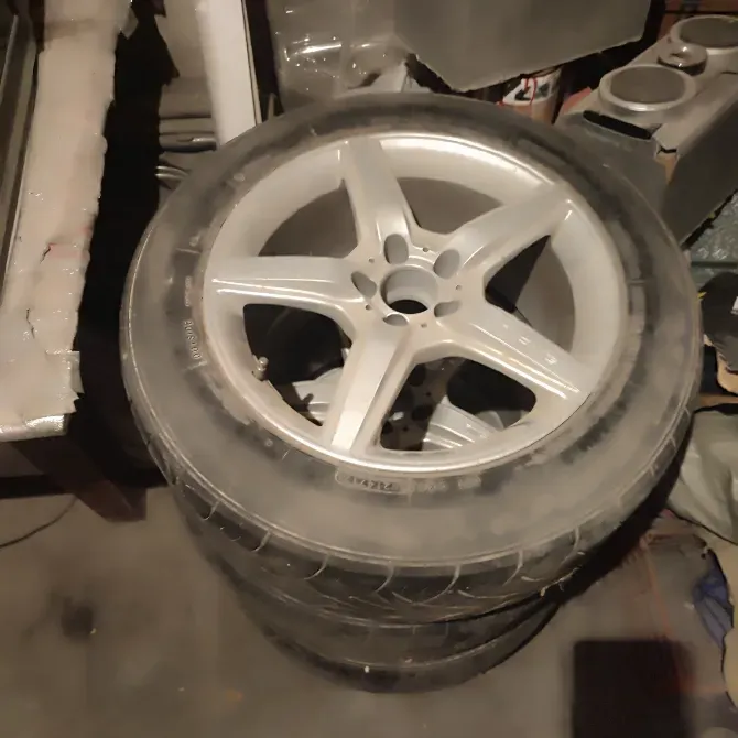 Шины на дисках с несколькими углами обзора, изображенные на фоне гаража