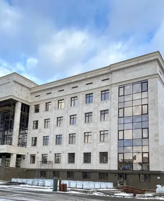 Современное здание с большими окнами и отделкой из светлого камня