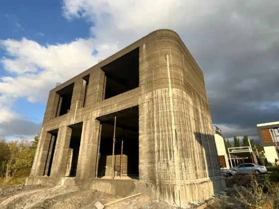 Современный дом с необычным дизайном и зелеными насаждениями вокруг