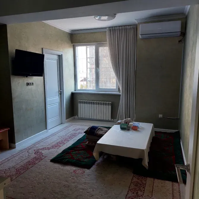 Комната с зелеными стенами, телевизором и столом