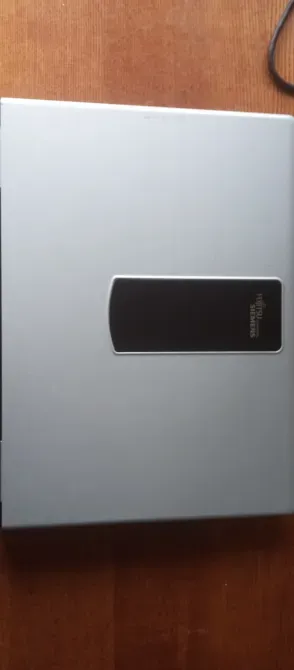 Ноутбуктың артқы жағындағы техникалық деректер мен сериялық нөмірлері бар жапсырма